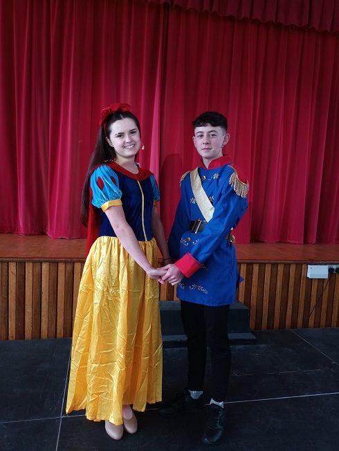 Female and male in costume holding hands on stage