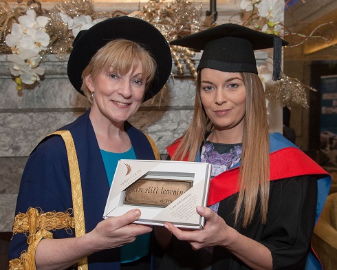 Principal of the College presenting an award to a female graduate