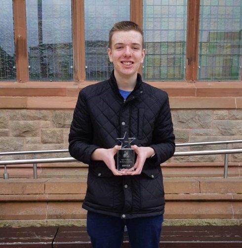 Male student holding an award