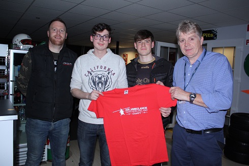 Group of male students and lecturer holding a red t shirt