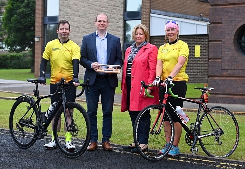 Group with bicyles and minister holding a baton