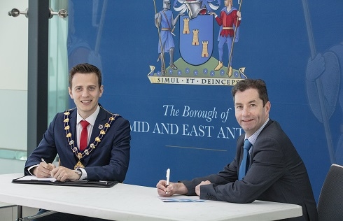 Two males signing a document