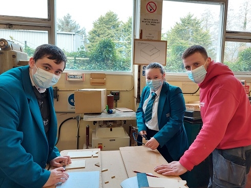 Three students in carpentry and joinery workshop