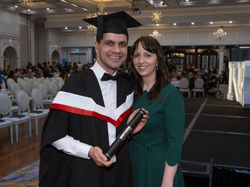 Male in graduation gown with his wife