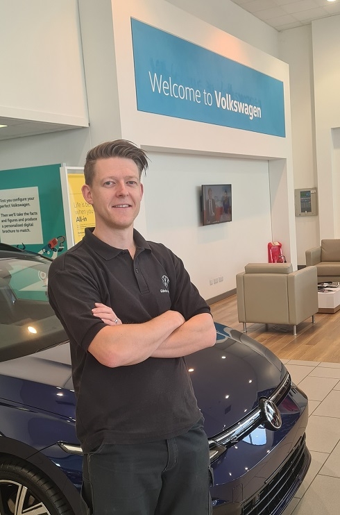 Male standing against a car