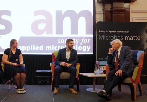 Female technician sitting on stage with David Attenborough and another male