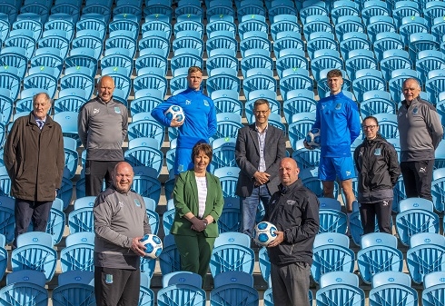 Male and females standing in stadium stand