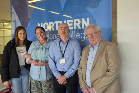 Award recipient with family and staff member