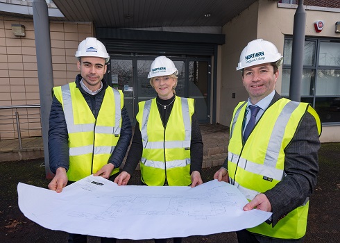 Local contractor and Vice-Principal with hard hats and plans of the campus