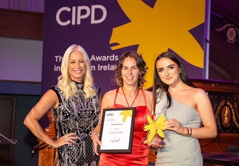 Three females holding an award