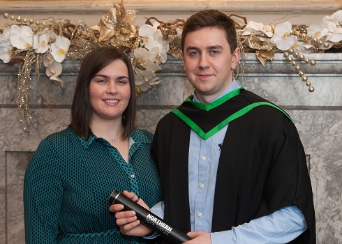Male student in graduation gown with a female