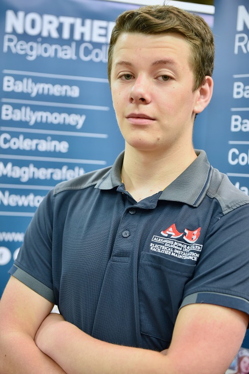 Male apprentices standing in front of branded pullup stand
