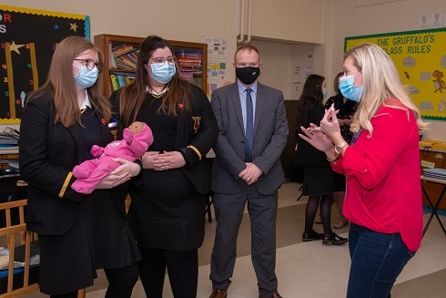 Two females holding a virtual baby getting advice from female lecturer