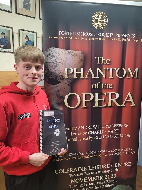 Male holding a phantom of the opera programme
