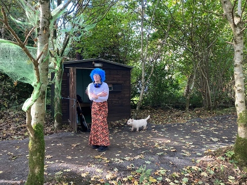 Female in costume with dog in a woodland area