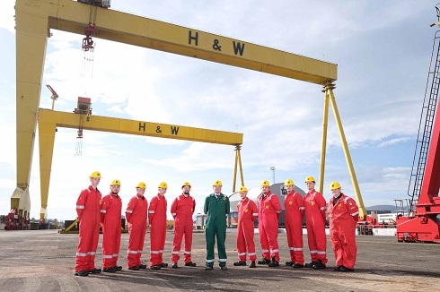 Group in male wearing overalls standing outside Harland and Wolff