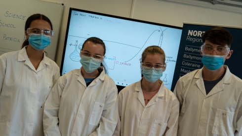 Four students in white lab coats