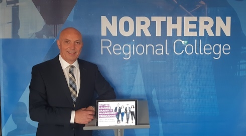 Male standing next to tablet displaying a Future Leaders Programme image