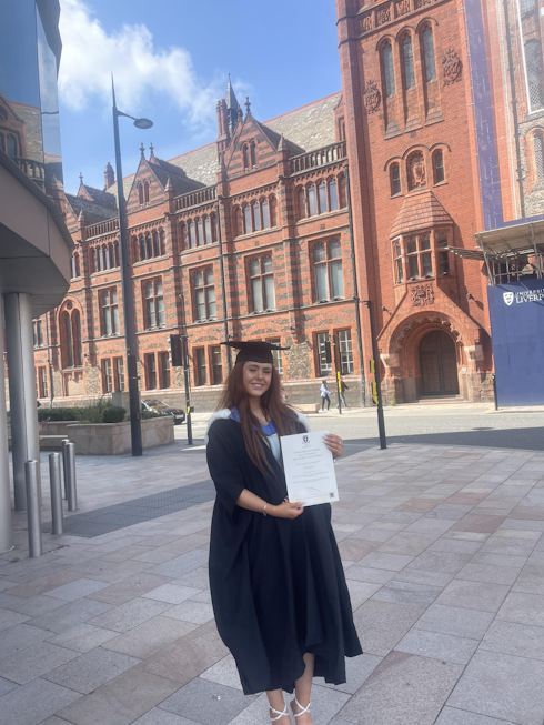 Female wearing graduation robe and holding certificate