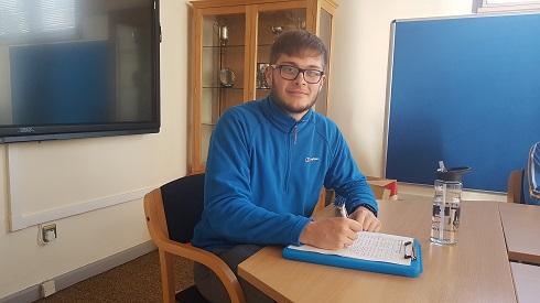 Male sports student sitting at a desk