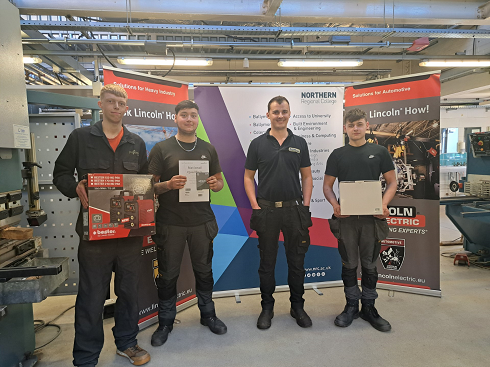 Group of winners with their awards in engineering workshop