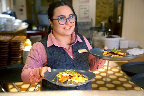 Female apprentice holding plates getting ready to serve food