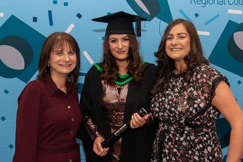 Female wearing graduation robe with her family
