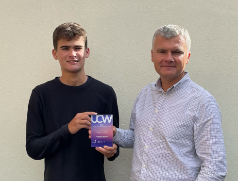 Male student holding an award
