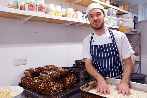 Male apprentice wearing chef whites in the kitchen