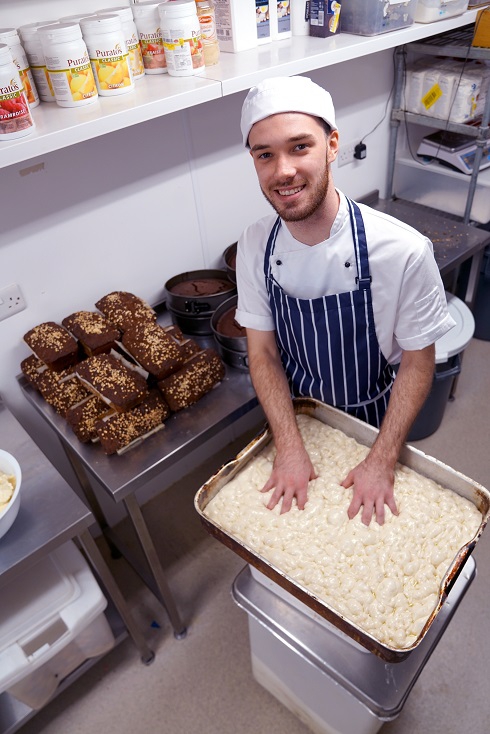 Male apprentice in chef whites in the kitchen