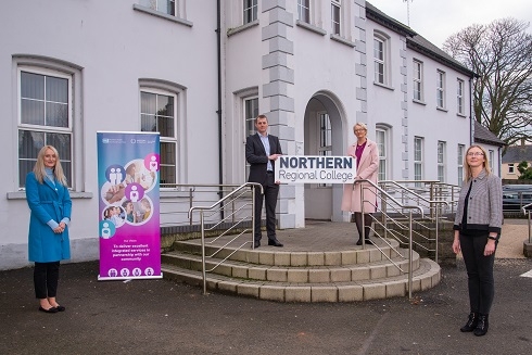 Group of people standing outside a building holding NRC prop