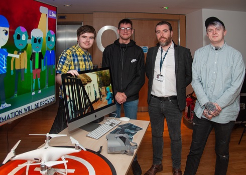 Group of students standing next to their creative work