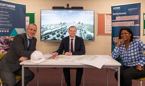 Three people sitting at table looking at survey drawings