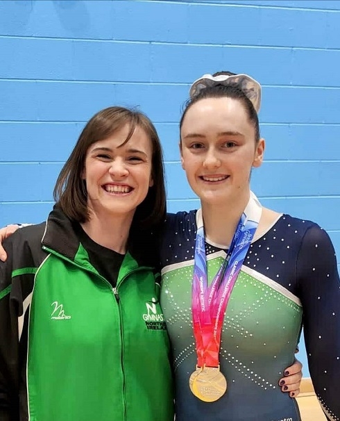 Female with medal accompanied by her female coach