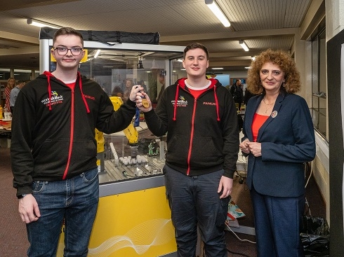 Female lecturer with two male apprentices holding gold medals
