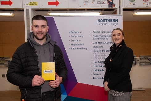 Male student holding a congrats certificate with a female