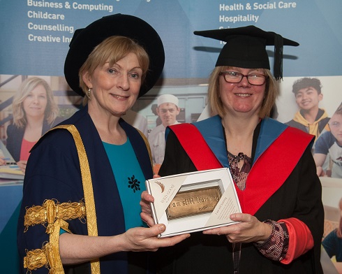 Principal presenting a female graduate a lifelong learning award