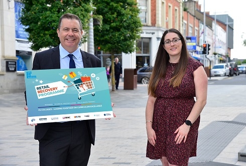 Male and female standing in street with prop