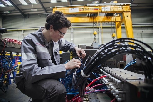 Male apprentice working on electrical cables