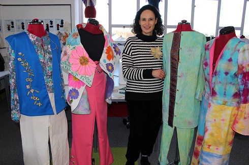 Female student standing next to clothed manequins