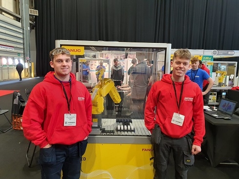 Two males standing next to robotics