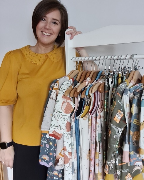 Female standing next to clothes rail