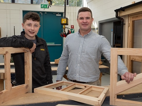 Two males standing in workshop