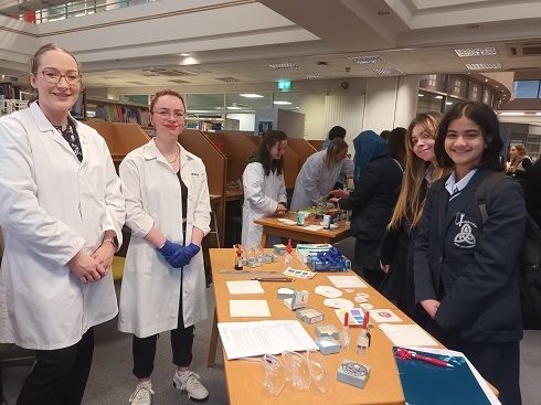 Females standing around a science stand