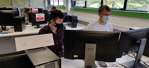 Two males sitting at computer