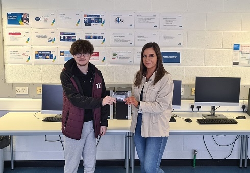Female lecturer handing prize to male student