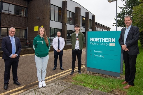 Large group of apprentices standing outside building