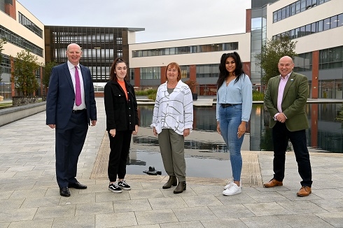 Group of male and female standing outside a building