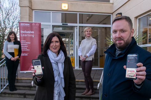 Staff standing outside holding a mobile phone