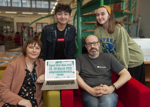 Group including students and staff holding a laptop advertising the Digital Skills Week